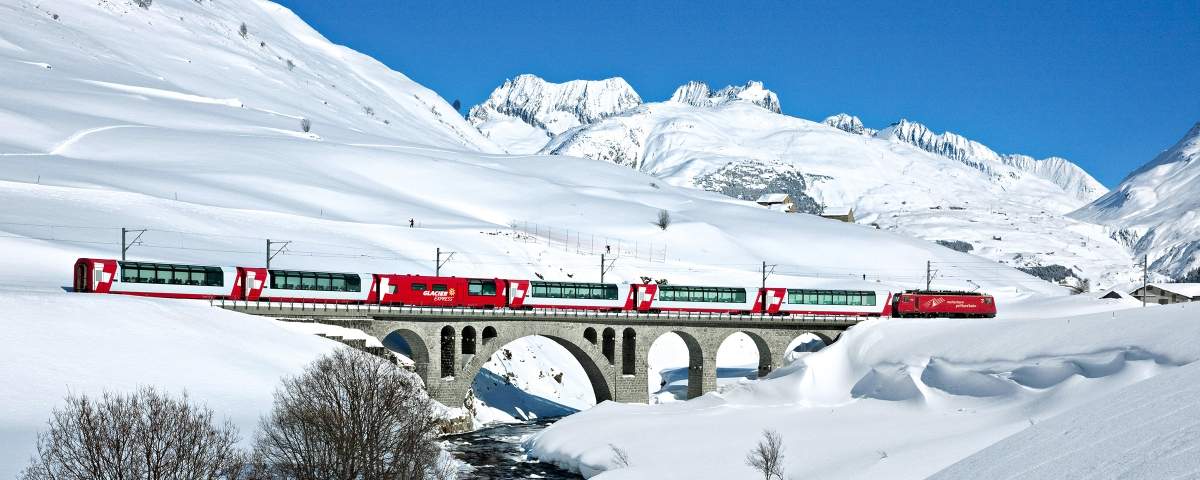The Glacier Express in the snowed Urserental near the village Hospental in the canton of Uri.