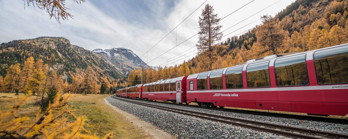The Bernina Express in colourfull Autumn landscape.