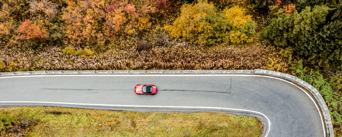 a car driving along the Grand Tour of Switzerland in autumn