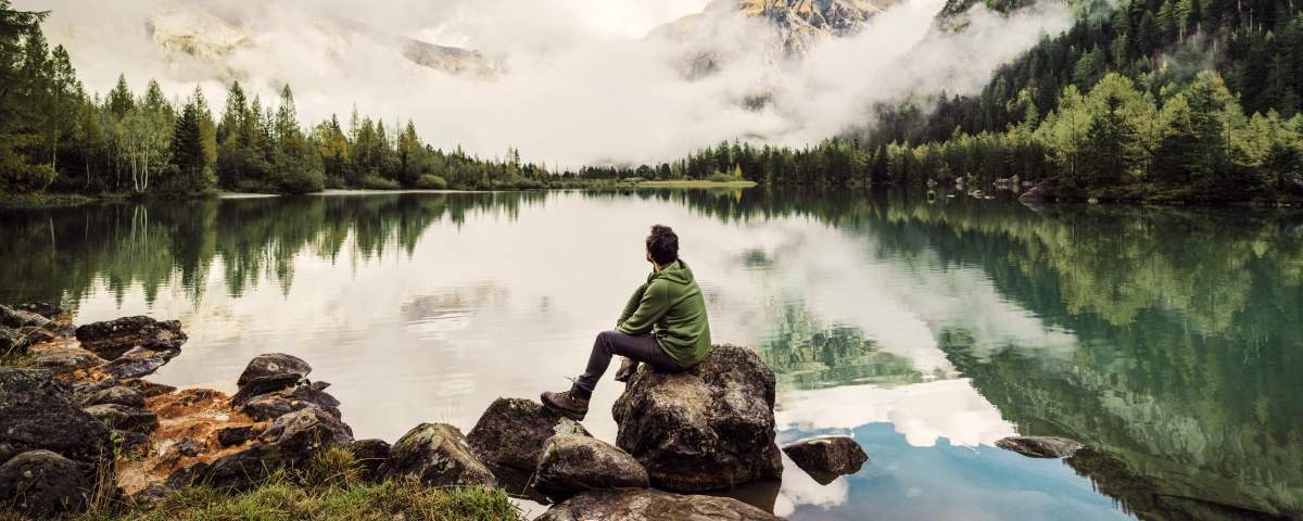 Hiker sitting by a lake in the mountains