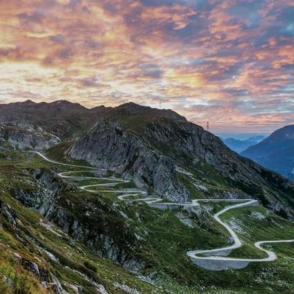 alpine pass in Switzerland with a colourful sky in the background