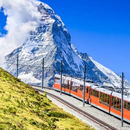 train in front of majestic Matterhorn in summer