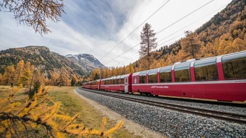 The Bernina Express in colourfull Autumn landscape.