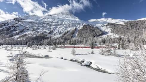 Bernina Express in winter with mountains in background
