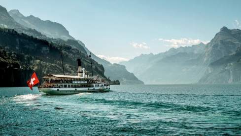 Paddle steamer boat on lake lucerne with mountains in the background
